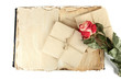 Open old book, letters and rose isolated on white