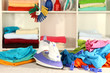 Clothes and iron on table on shelves background