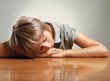 A tired woman sleeping on the desk, isolated on grey