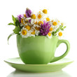Beautiful wild flowers and mint in cup, isolated on white