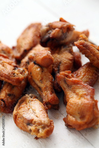Photo: Grilled chicken wings on a white table Grilled chicken wings on a white table