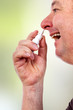 Man spraying nose drops