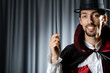 Magician in the dark room with wand