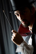 Magician in the dark room with wand