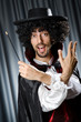 Magician in the dark room with wand