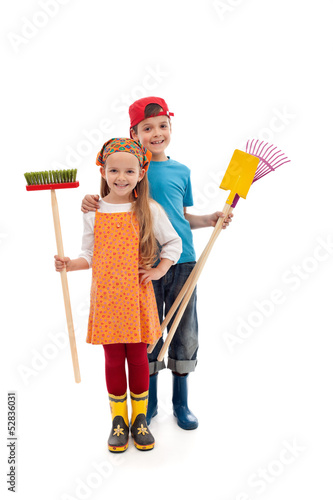 Photo: Kids with gardening utensils and rubber boots - isolated Kids with gardening utensils and rubber boots - isolated
