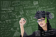 Asian graduate writing on board in class