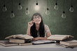 Asian student has bright idea under light bulbs