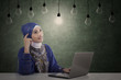 Beautiful muslim has idea under light bulbs