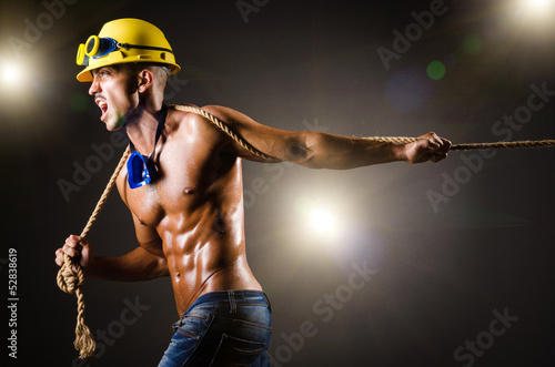 Photo: Nude builder pulling rope in darkness Nude builder pulling rope in darkness