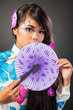 Beautiful asian woman wears a national dress is holding a fan