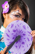 Beautiful asian woman wears a national dress is holding a fan