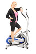 Photo: Mature woman athlete on a cross trainer fitness machine Mature woman athlete on a cross trainer fitness machine