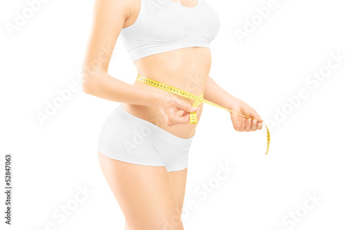 Photo: Young woman in white cotton underwear measuring her waist Young woman in white cotton underwear measuring her waist