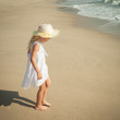 happy little girl standing on beach