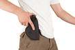 Close-up of a man with his hand on a gun