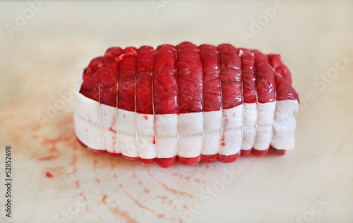 Photo: Classic french beef roast, tied with strings and fat, raw meat Classic french beef roast, tied with strings and fat, raw meat