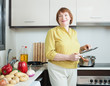 Smiling mature woman  in domestic kitchen