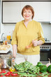  woman with heap of okra in  kitchen