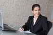 Young brunette businesswoman with laptop and smartphone