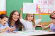 Foto: Teacher With Girl Showing Drawing At Desk Teacher With Girl Showing Drawing At Desk