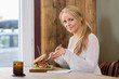 Photo: Young Woman Eating Sandwich At Cafe Young Woman Eating Sandwich At Cafe