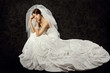 Photo: Bride in wedding dress over dark background Bride in wedding dress over dark background