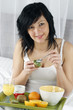 JEUNE FEMME PRENANT SON PETIT DEJEUNER AU LIT
