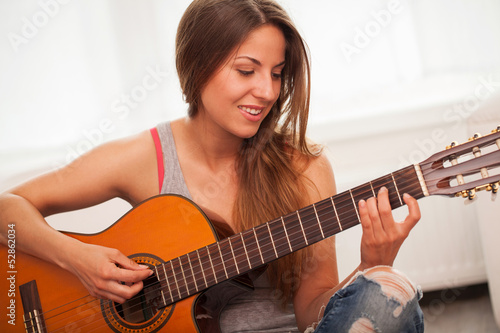 Photo: Young beautiful woman playing guitar Young beautiful woman playing guitar