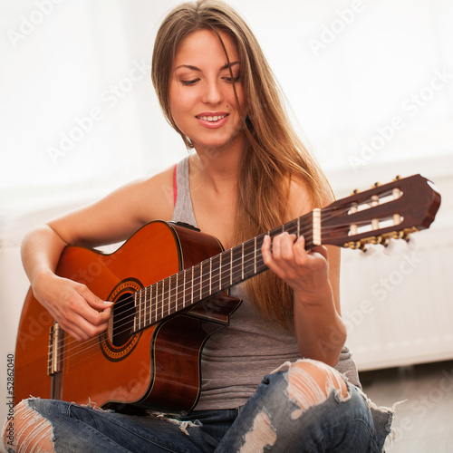 Photo: Young beautiful woman playing guitar Young beautiful woman playing guitar