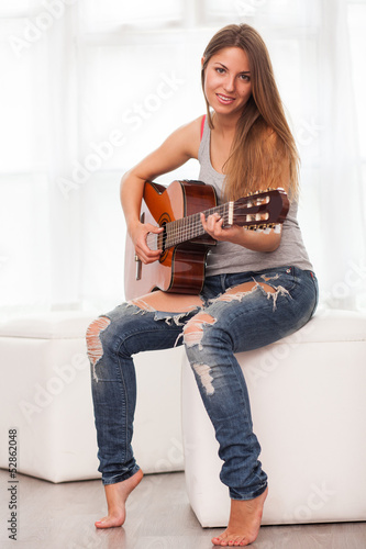 Photo: Young beautiful woman playing guitar Young beautiful woman playing guitar