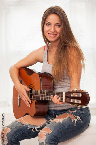 Photo: Young beautiful woman playing guitar Young beautiful woman playing guitar