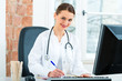 Female doctor writing in document