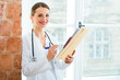 Doctor in clinic writing in a file