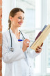 Doctor in clinic writing in a file