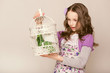 fashion little girl looks on birdcage