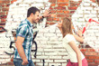 young couple against graffiti wall
