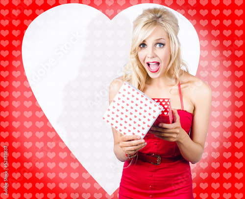 Photo: Surprised attractive girl with heart gift box Surprised attractive girl with heart gift box