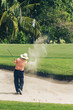 Asian golfer in bunker on golf course