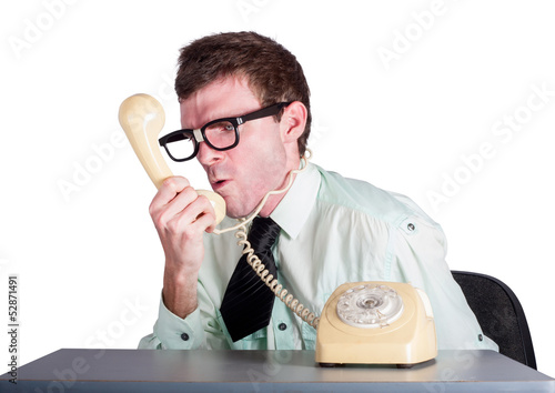 Photo: Angry businessman yelling down phone Angry businessman yelling down phone