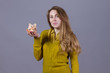 Nice girl with piggy bank at her hand at gray background
