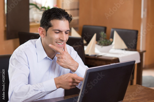 Photo: Mann deutet lachend auf Notebook Mann deutet lachend auf Notebook