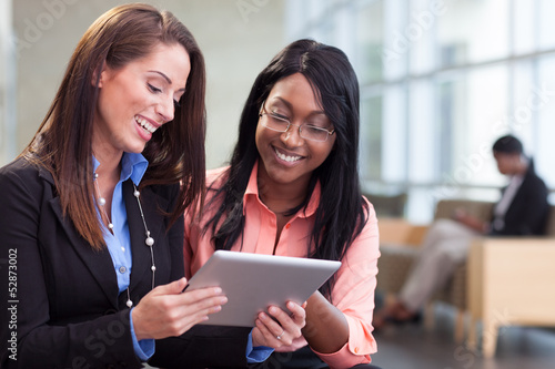 Photo: Two businesswomen in lobby Two businesswomen in lobby