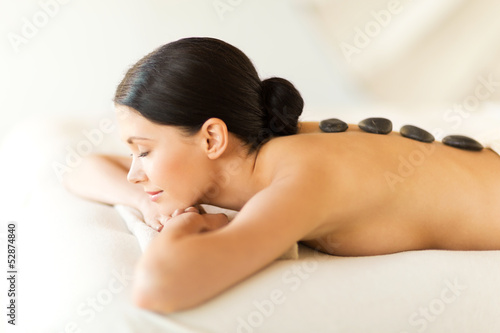 Photo: woman in spa with hot stones woman in spa with hot stones