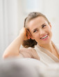 Photo: Portrait of smiling young housewife in living room Portrait of smiling young housewife in living room