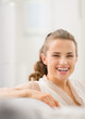 Photo: Portrait of happy young housewife in living room Portrait of happy young housewife in living room