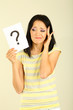 Photo: Woman with question marks on grey background Woman with question marks on grey background