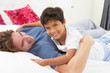 Father And Son Lying In Bed Together