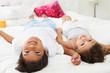 Children Lying Upside Down On Bed In Pajamas Together