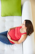 Foto: Overhead View Of Pregnant Woman Relaxing On Sofa Overhead View Of Pregnant Woman Relaxing On Sofa